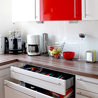 Schubladenschrank in rot-weißer Einbauküche